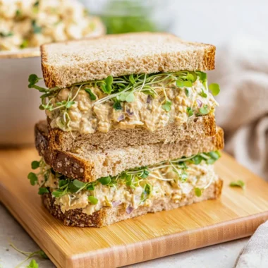 Chickpea salad sandwich filled with fresh ingredients on whole grain bread.