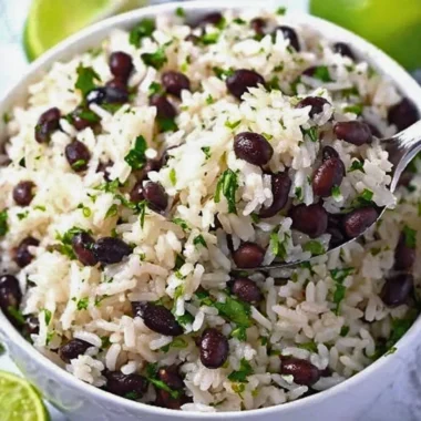 Bowl of Cilantro Lime Rice with Black Beans garnished with lime and cilantro
