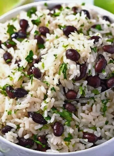 Bowl of Cilantro Lime Rice with Black Beans garnished with lime and cilantro
