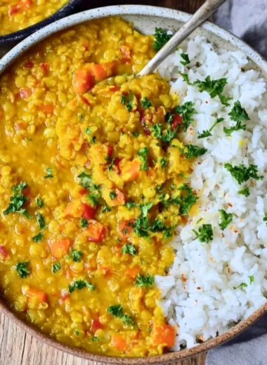 Creamy red lentil dahl served in a bowl with herbs and spices