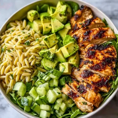 Colorful Grilled Chicken Orzo Salad topped with fresh vegetables and herbs