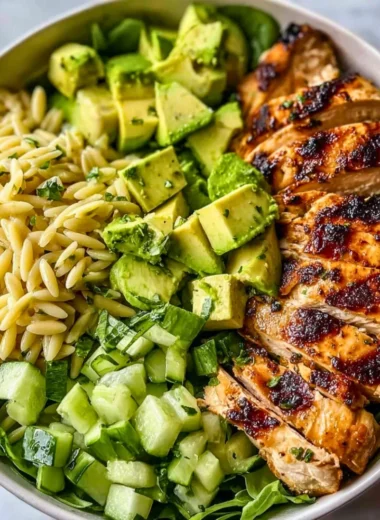 Colorful Grilled Chicken Orzo Salad topped with fresh vegetables and herbs