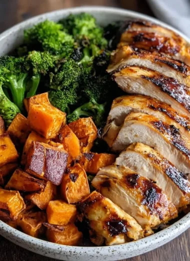 Grilled chicken and sweet potato bowl garnished with fresh herbs