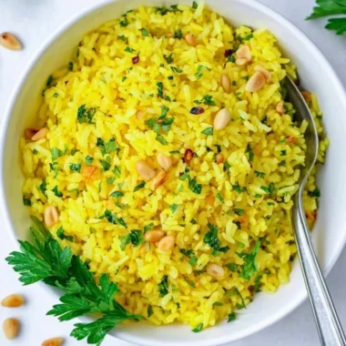 Bowl of Mediterranean yellow rice topped with herbs and spices