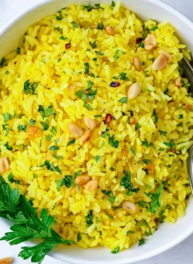 Bowl of Mediterranean yellow rice topped with herbs and spices