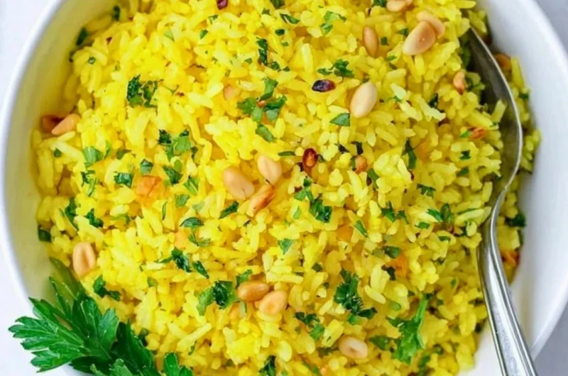 Bowl of Mediterranean yellow rice topped with herbs and spices