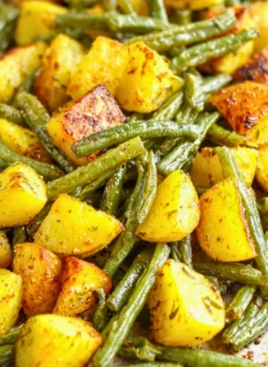 Delicious oven-roasted potatoes with green beans served on a plate.
