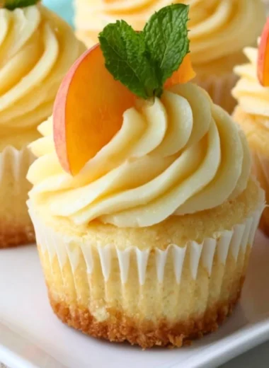Delicious peach honey cheesecake cupcakes topped with fruit and honey.