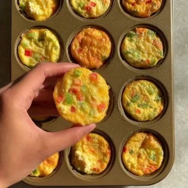 Delicious breakfast egg muffins with vegetables and cheese on a plate.