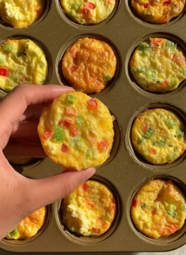 Delicious breakfast egg muffins with vegetables and cheese on a plate.