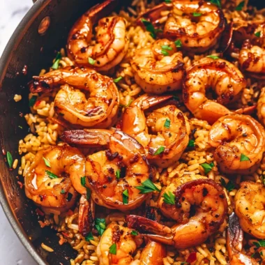 Cajun shrimp and rice skillet dish garnished with fresh herbs.