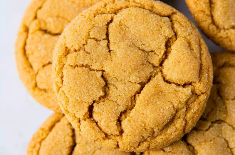 A plate of freshly baked chewy brown sugar cookies with a golden brown hue.