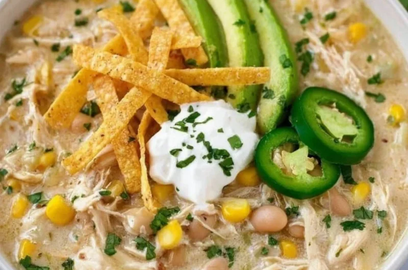 Bowl of creamy white chicken chili garnished with cilantro and lime.