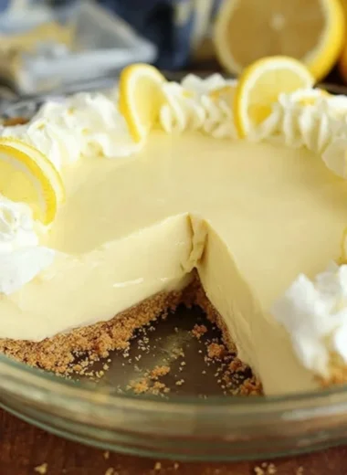 Slice of easy lemon cream pie topped with whipped cream and lemon zest