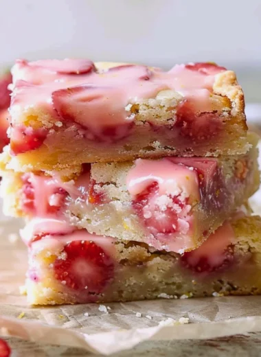 Easy strawberry lemon blondies on a plate with fresh strawberries and lemon slices