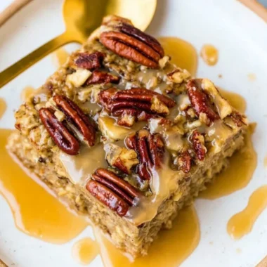 Delicious Maple Pecan Baked Oatmeal served in a bowl with nuts and maple syrup.