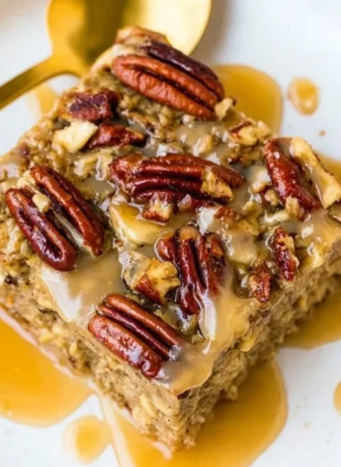 Delicious Maple Pecan Baked Oatmeal served in a bowl with nuts and maple syrup.