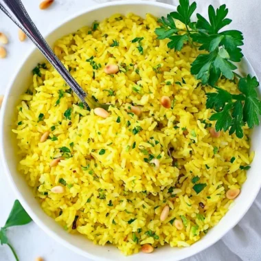 Bowl of Mediterranean Yellow Rice garnished with fresh herbs and spices.