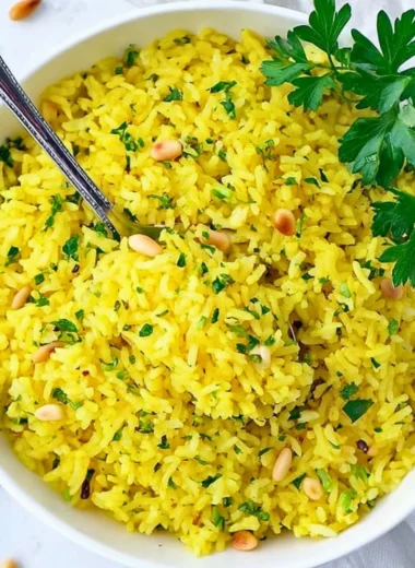 Bowl of Mediterranean Yellow Rice garnished with fresh herbs and spices.