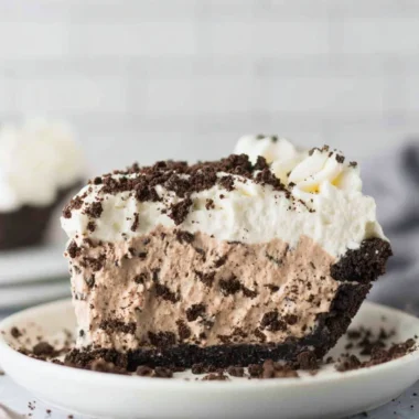 Deliciously layered Oreo Pudding Pie with whipped cream and cookie crumbles