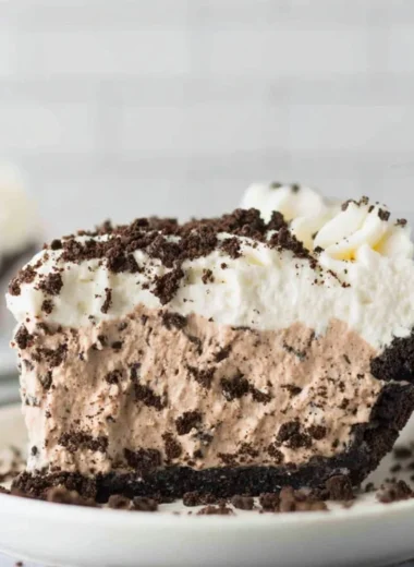 Deliciously layered Oreo Pudding Pie with whipped cream and cookie crumbles