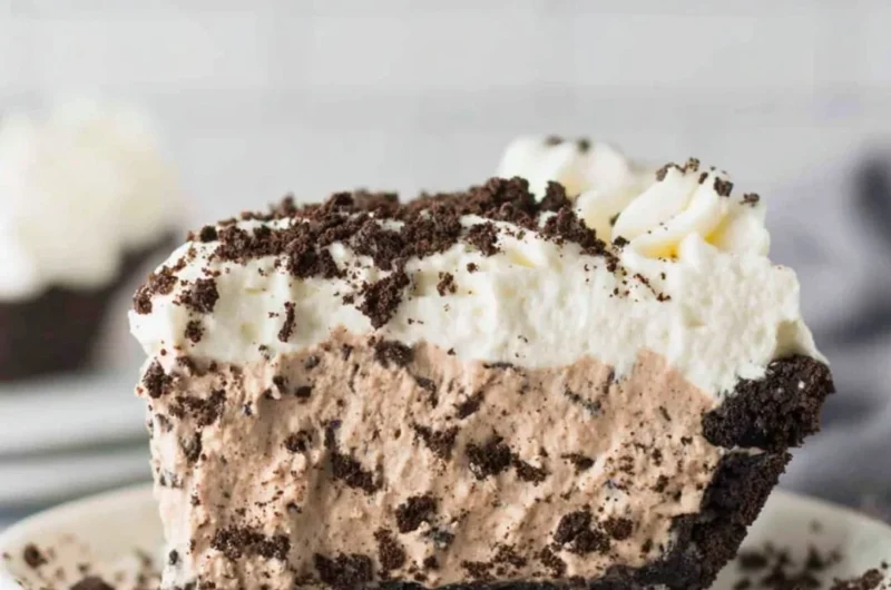 Deliciously layered Oreo Pudding Pie with whipped cream and cookie crumbles