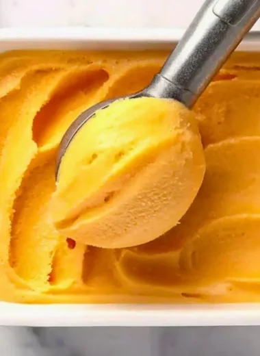 Delicious homemade Peach Sorbet served in a bowl with fresh peach slices