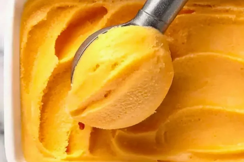 Delicious homemade Peach Sorbet served in a bowl with fresh peach slices
