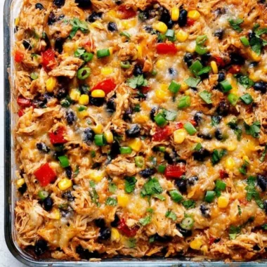 Protein Burrito Casserole topped with cheese and garnished with fresh herbs.