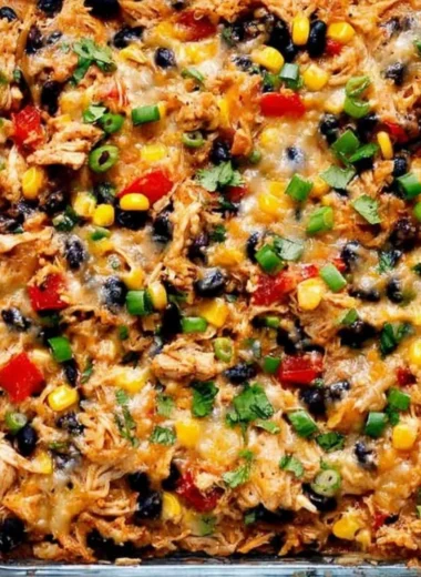 Protein Burrito Casserole topped with cheese and garnished with fresh herbs.