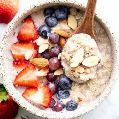 Strawberry quinoa breakfast bowl topped with fresh berries and nuts