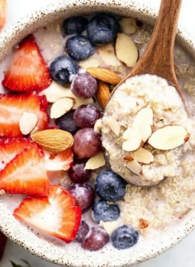 Strawberry quinoa breakfast bowl topped with fresh berries and nuts