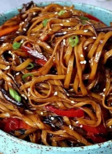 Colorful vegetable stir-fry noodles cooked in a wok with fresh ingredients.