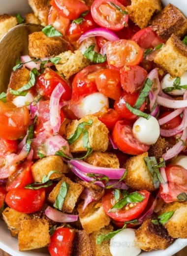 A vibrant bread salad featuring fresh vegetables and crispy bread pieces.