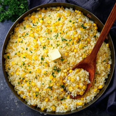 Delicious buttered corn rice served in a bowl with fresh herbs.