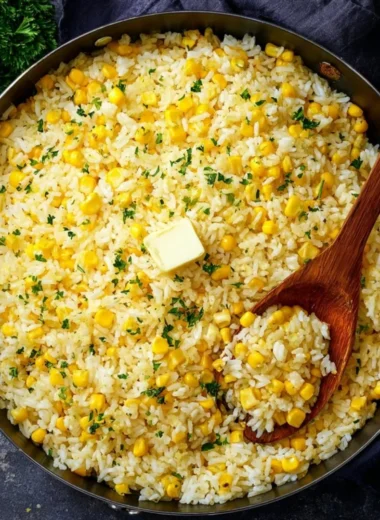 Delicious buttered corn rice served in a bowl with fresh herbs.