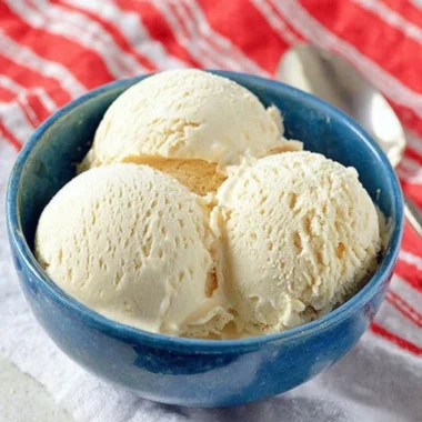 Delicious Cold Stone cake batter ice cream in a cone, topped with sprinkles.