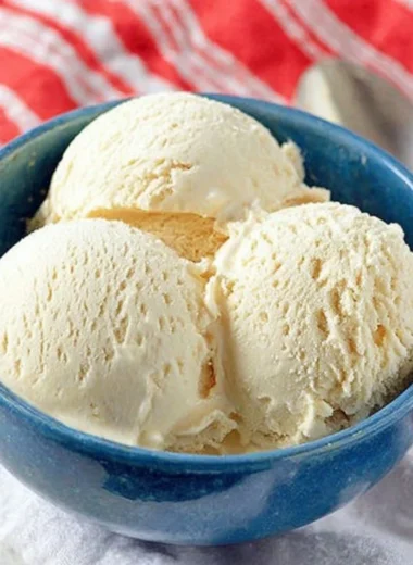 Delicious Cold Stone cake batter ice cream in a cone, topped with sprinkles.