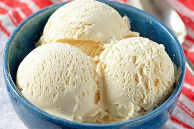 Delicious Cold Stone cake batter ice cream in a cone, topped with sprinkles.