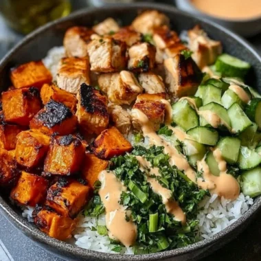 A vibrant grilled chicken salad topped with fresh vegetables and dressing.