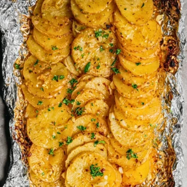 Grilled garlic butter potatoes served on a plate with herbs and spices.