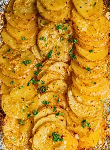 Grilled garlic butter potatoes served on a plate with herbs and spices.