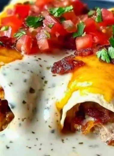 Creamy jalapeño popper cheesy chicken enchiladas topped with cheese and jalapeños