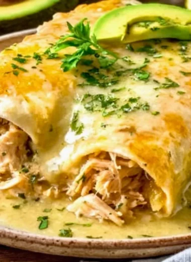 Plate of Joanna Gaines' chicken enchiladas garnished with cilantro and cheese