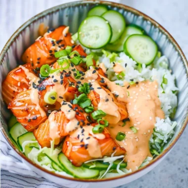 Delicious spicy salmon bowl garnished with fresh vegetables and sauce