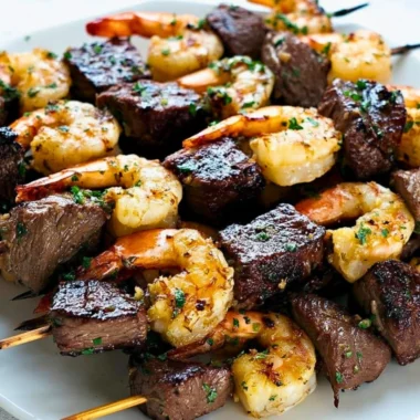 Delicious Surf and Turf Kebabs served with Chimichurri Sauce on a platter.
