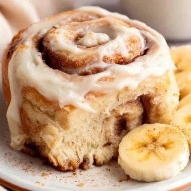 Delicious banana bread cinnamon rolls topped with creamy frosting.