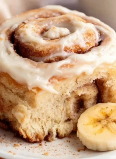 Delicious banana bread cinnamon rolls topped with creamy frosting.