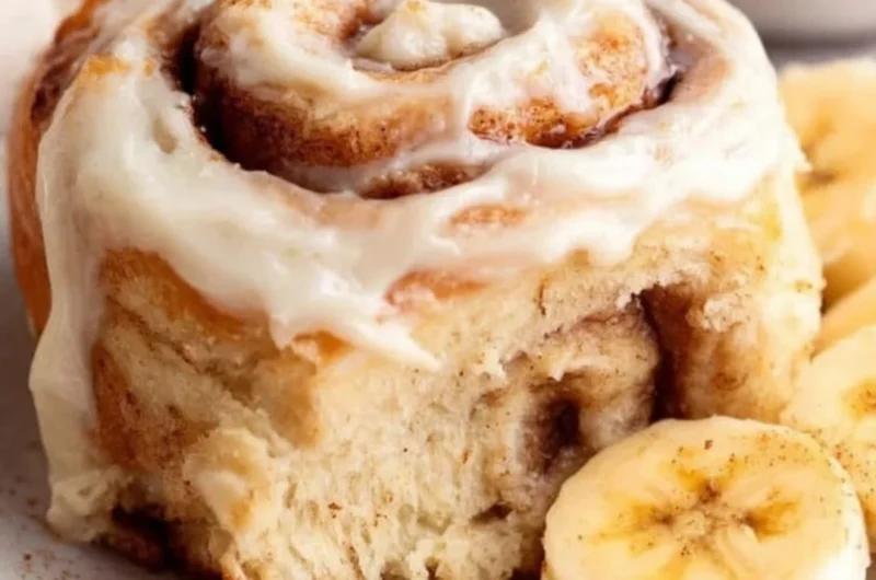 Delicious banana bread cinnamon rolls topped with creamy frosting.