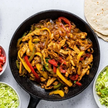 Delicious Chicken Fajitas with colorful peppers and onions served in a skillet.